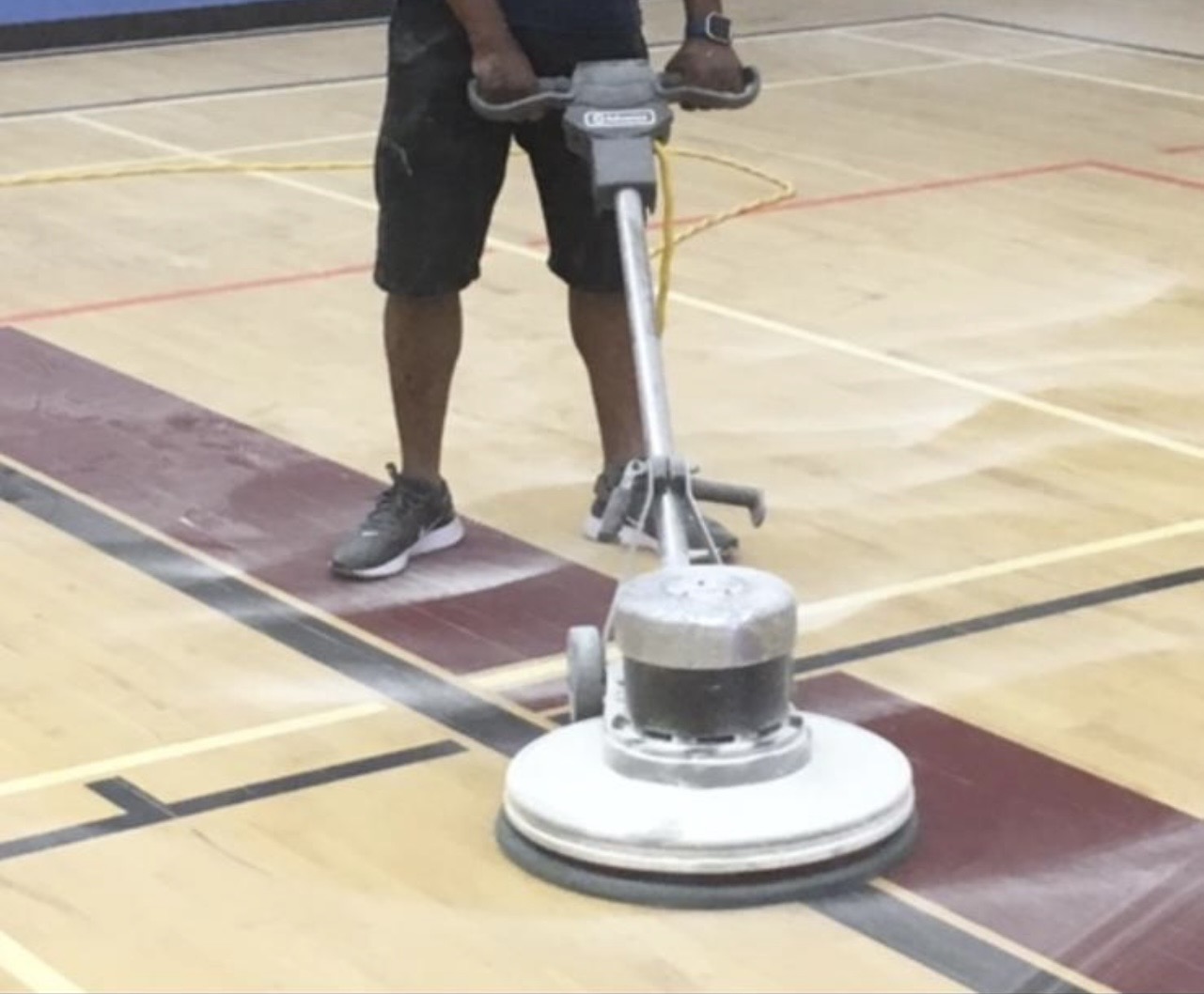 Technicien de Le Bon Ménage Québec effectuant la réfection d'un plancher de gymnase